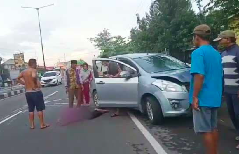 MUSIBAH: Mobil Suzuki Ertiga yang dikemudikan warga Magelang dengan korban tergeletak di jalan. (foto: ist)