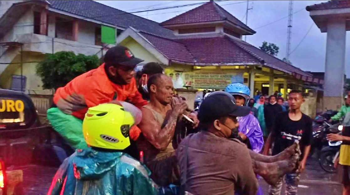 warga dan petugas kepolisian saat mengevakuasi korban erupsi gunung semeru