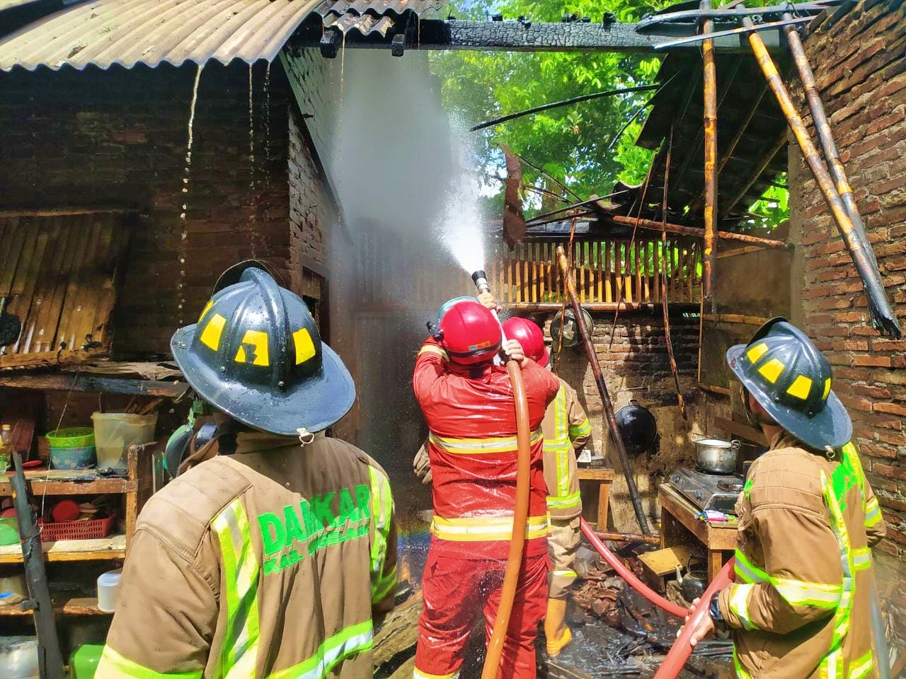 Petugas Damkar Kabupaten Magelang saat berupaya memadamkan api di sebuah rumah yang terbakar di Deyangan