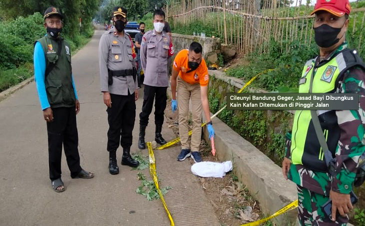 TEGA: Petugas melakukan olah TKP penemuan mayat bayi terbungkus kain kafan. (foto: ist)