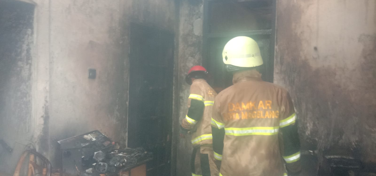 Petugas Damkar Kota Magelang melakukan pendinginan usai berhasil menjinakkan kobaran api. (foto: lift)