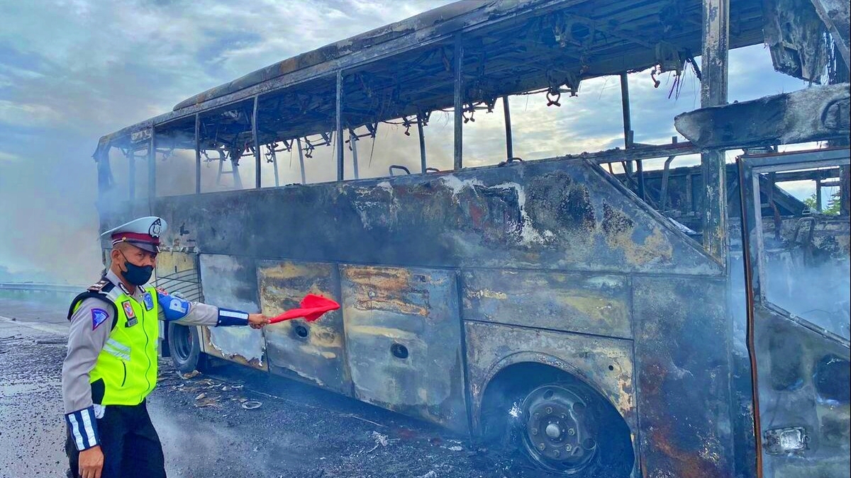 Petugas kepolisian sedang melakukan olah TKP bus pariwisata terbakar di Jalan Tol Pandaan