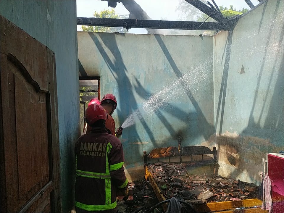 Petugas Damkar Kabupaten Magelang saat berupaya memadamkan api di sebuah rumah yang terbakar