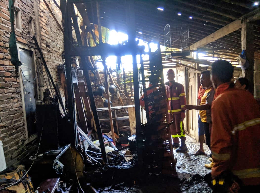 Petugas Damkar di sebuah rumah yang terbakar di Tempuran