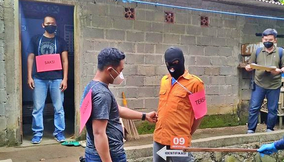 Petugs Polres Kulonprogo saat melakukan reka ulang adegan penganiayan seorang pria hingga meninggal dunia