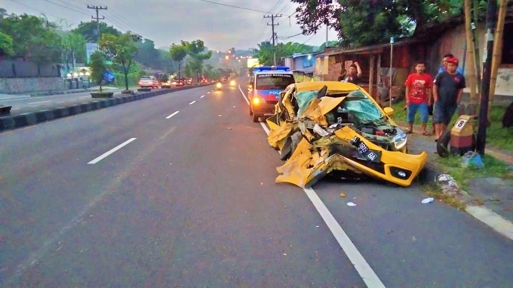 Mobil Brio warna kuning ringseng setelah tabrak truk dari belakang