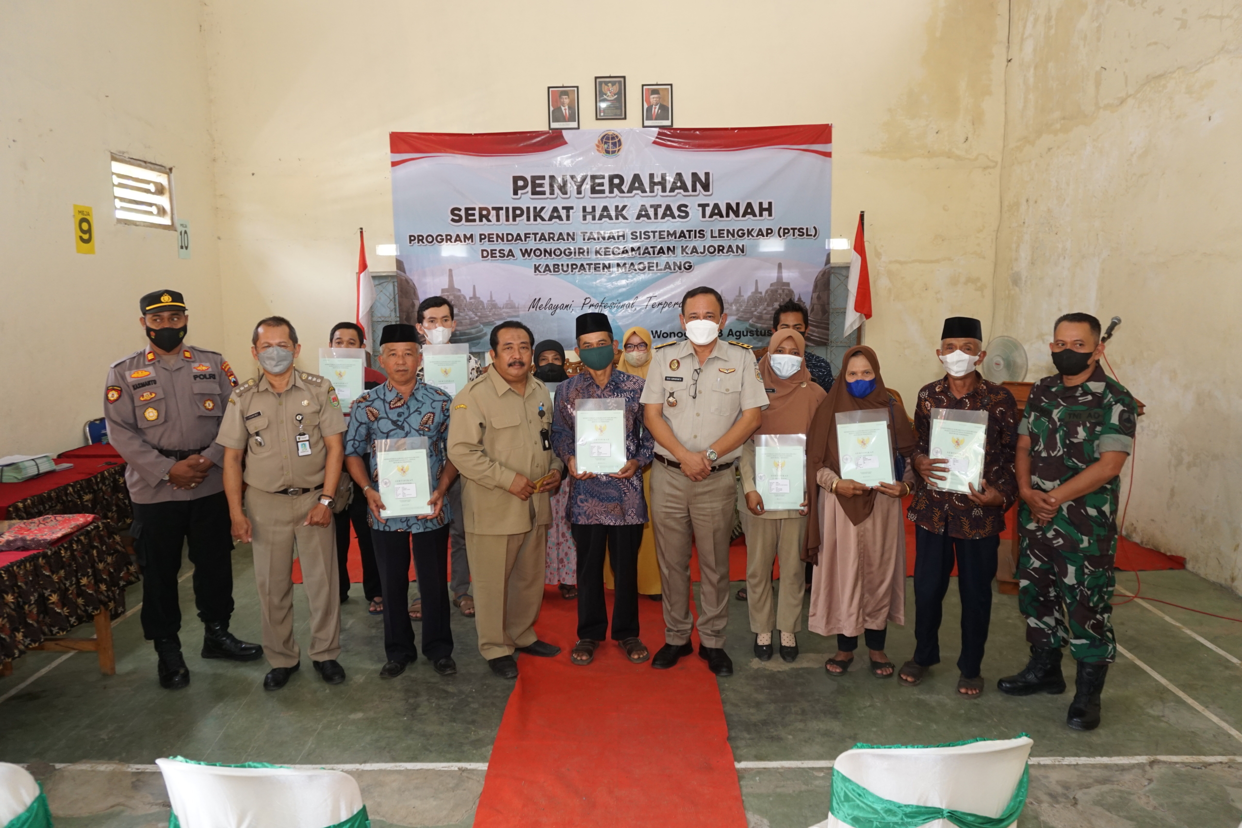 Asisten Administrasi Umum, Asfuri Muhsis bersama Ketua Panitia Ajudikasi PTSL Tim 1 BPN Kabupaten Magelang, Suparyanto saat menyerahkan sertifikat kepada masyarakat