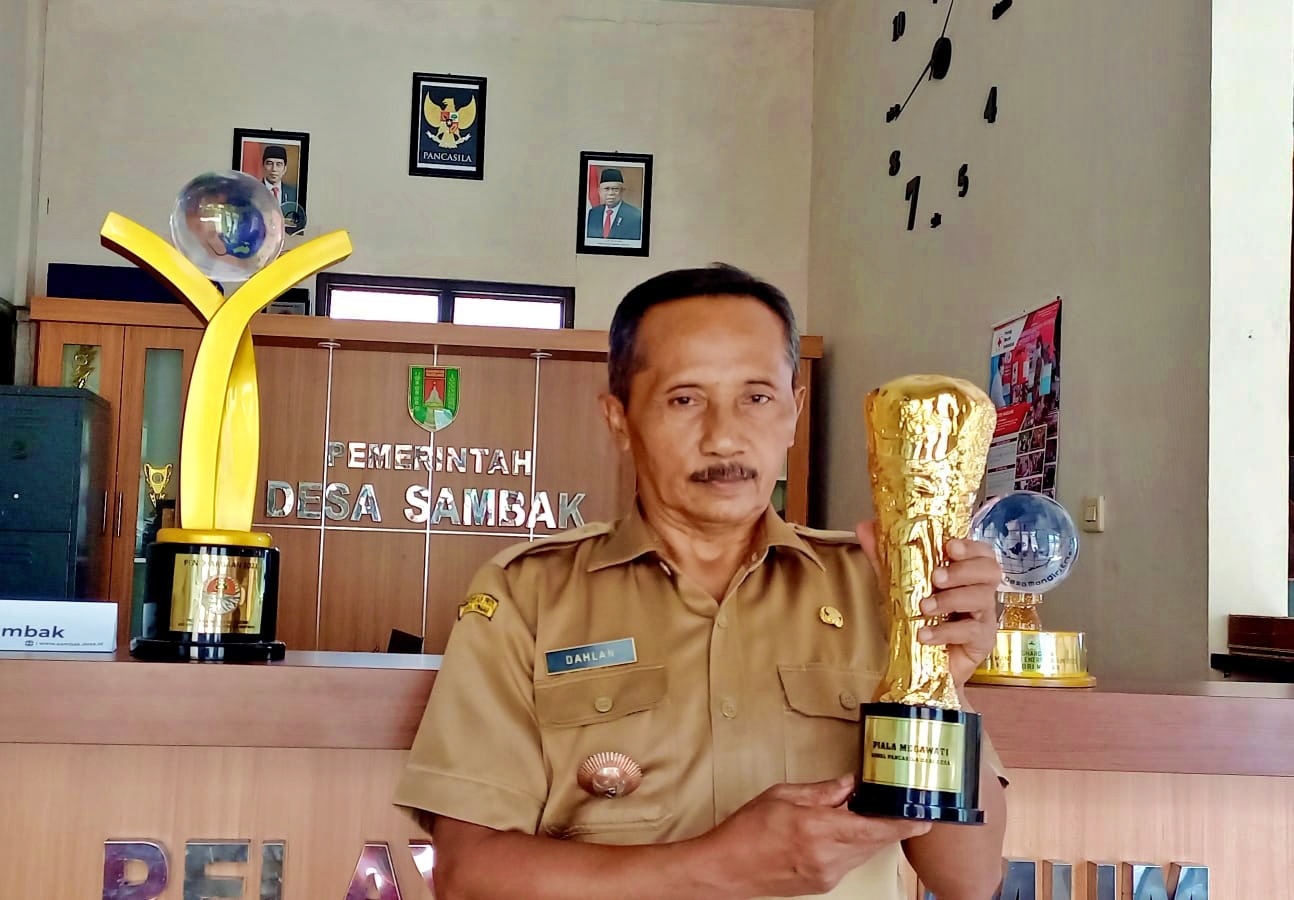 Kepala Desa Sambak Kajoran saat memamerkan Piala Megawati Kawal Pancasila Dari Desa