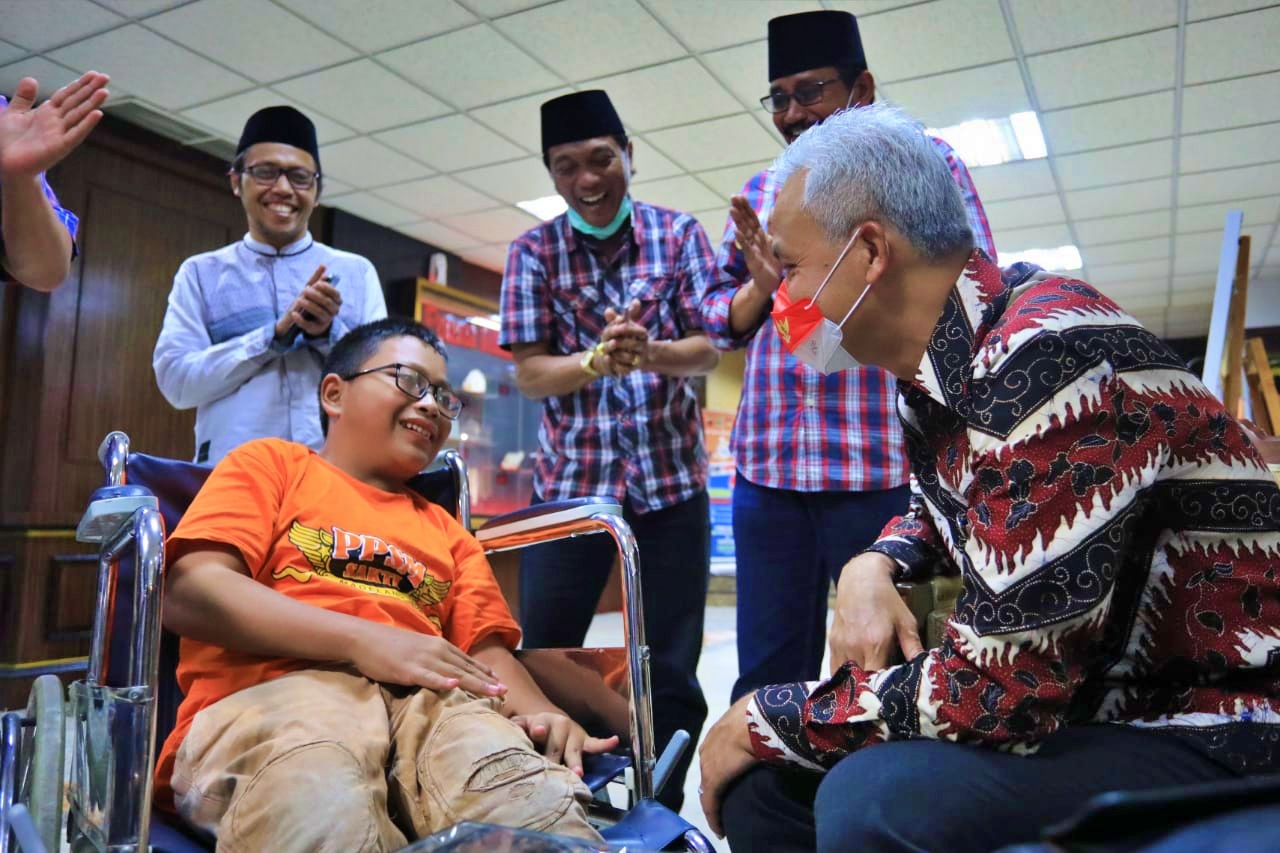 Ganjar saat memberikan kursi roda elektrik kepada Kholilur Rohman