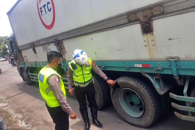 Polisi saat memeriksan ban truk yang pecah