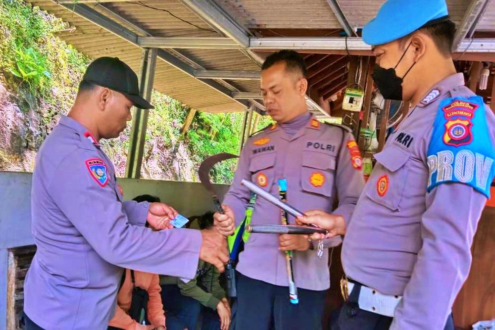 Petugas kepolisian saat mengamankan senjata tajam yang dibawa geng pelajar di Jogja