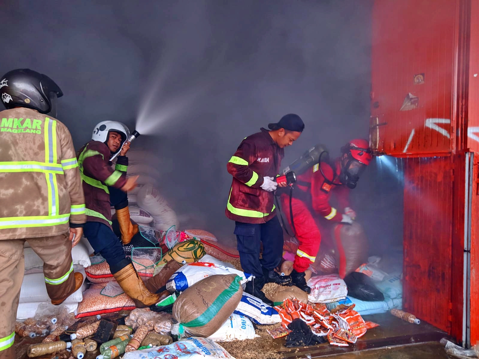 Petugas Damkar Kabupaten Magelang saat memadamkan api kebaakaran toko pakan ternak