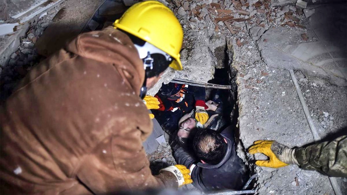 Petugas sedang mengevakuasi korban gempa turki suriah yang terjebak di bawa reruntuhan
