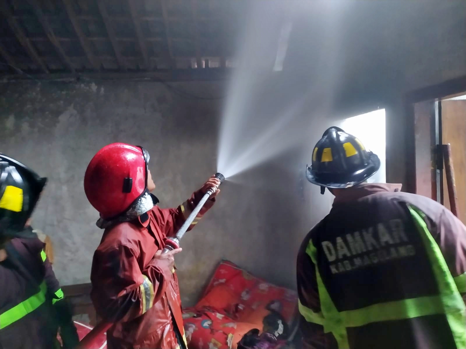 Petugas Damkar Kabupaten Magelang saat memadamkan kebakaran sebuah rumah di Muntilan