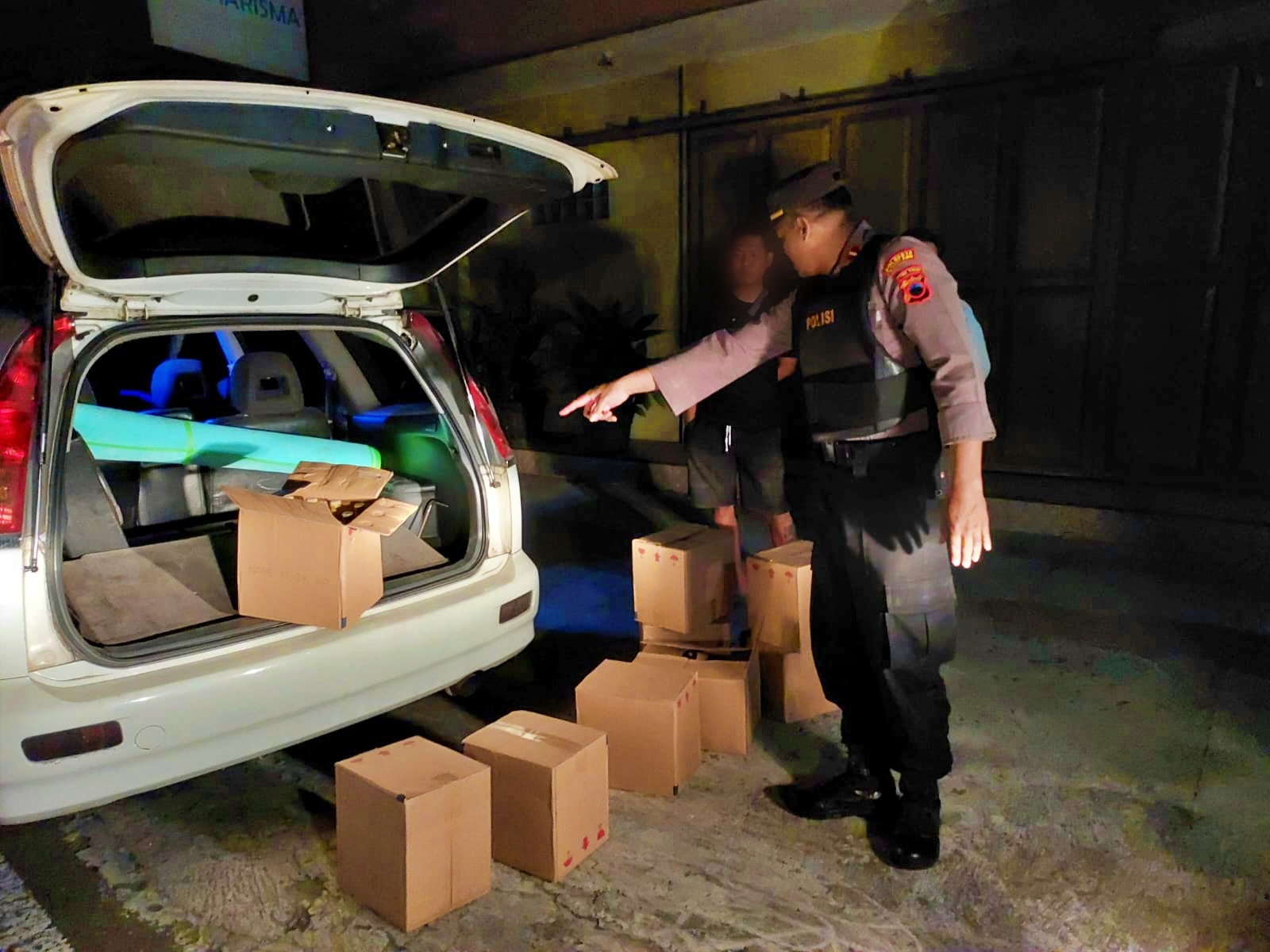 Petugas Polisi Polsek Muntilan saat mendapai ratusan botol miras di bagasi mobil saat patroli