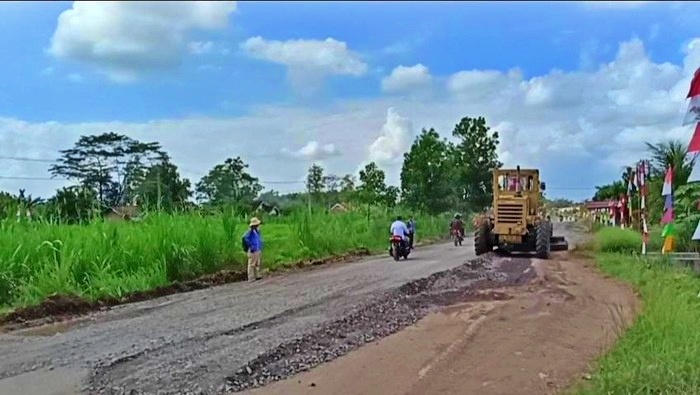 Alat berat yang bekerja menutupi lubang jalan di kecamatan Rumbia, Lampung Tengah