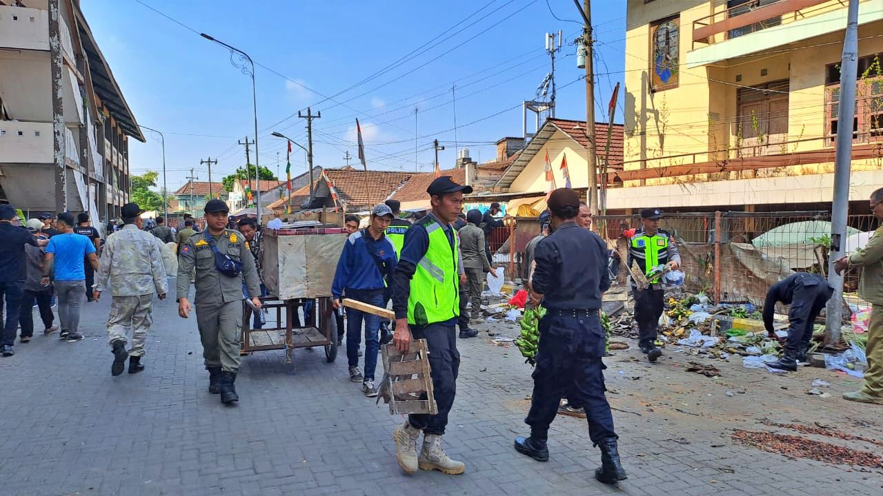 Petugas gabungan saat melakukan penertiban dan pembersihan lapak pedagang di luar bangunan Pasar Muntilan