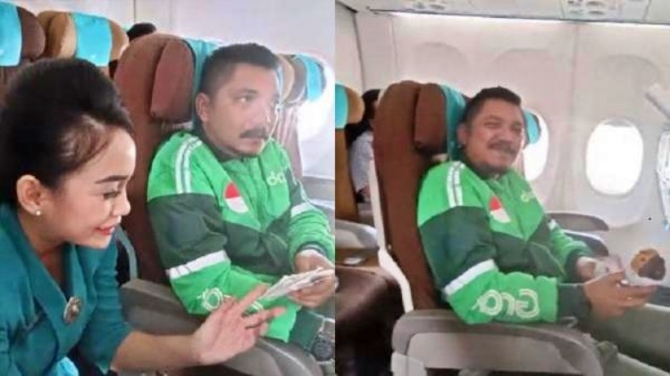 pria pakai jaket Ojol naik pesawat beli pesanan