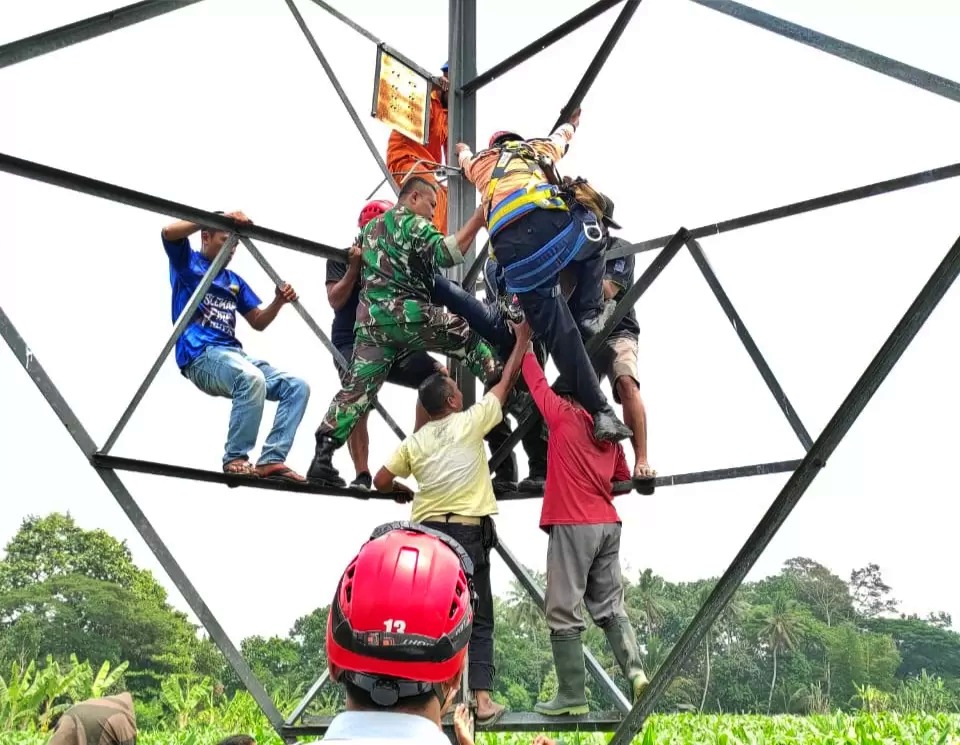 Petugas gabungan saat melakukan evakuasi mahasiswi yang memanjat tower sutet di Sleman