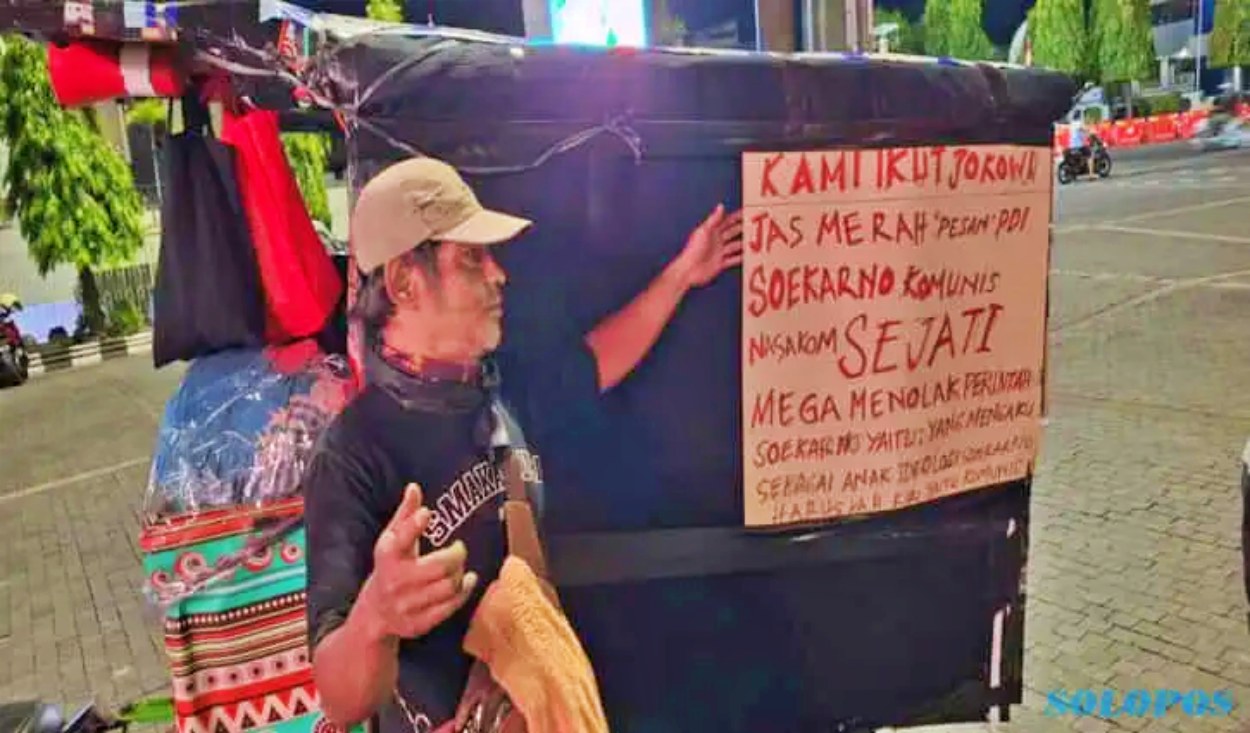 Sebuah gerobak milik seorang laki-laki paruh baya dipasangi tulisan-tulisan bernada provokatif bela jokowi_foto istimewa