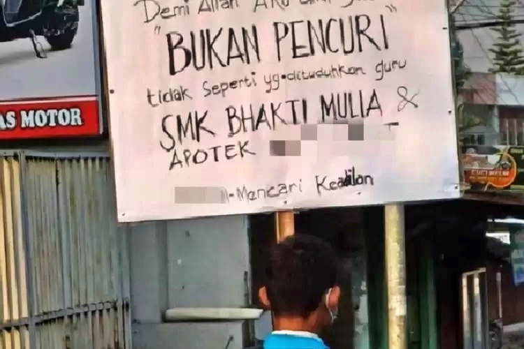 Seorang Siswa SMK membawa poster menuntut keadilan