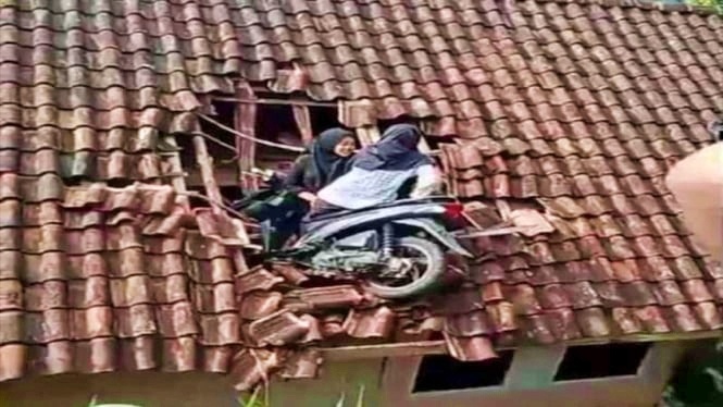 tangkapan layar video kecelakaan sepeda motor sampai di atap rumah warga