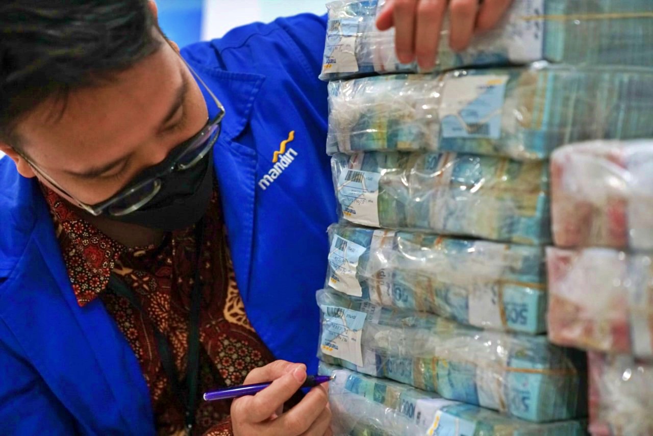 Pegawai Bank Mandiri saat memeriksa uang