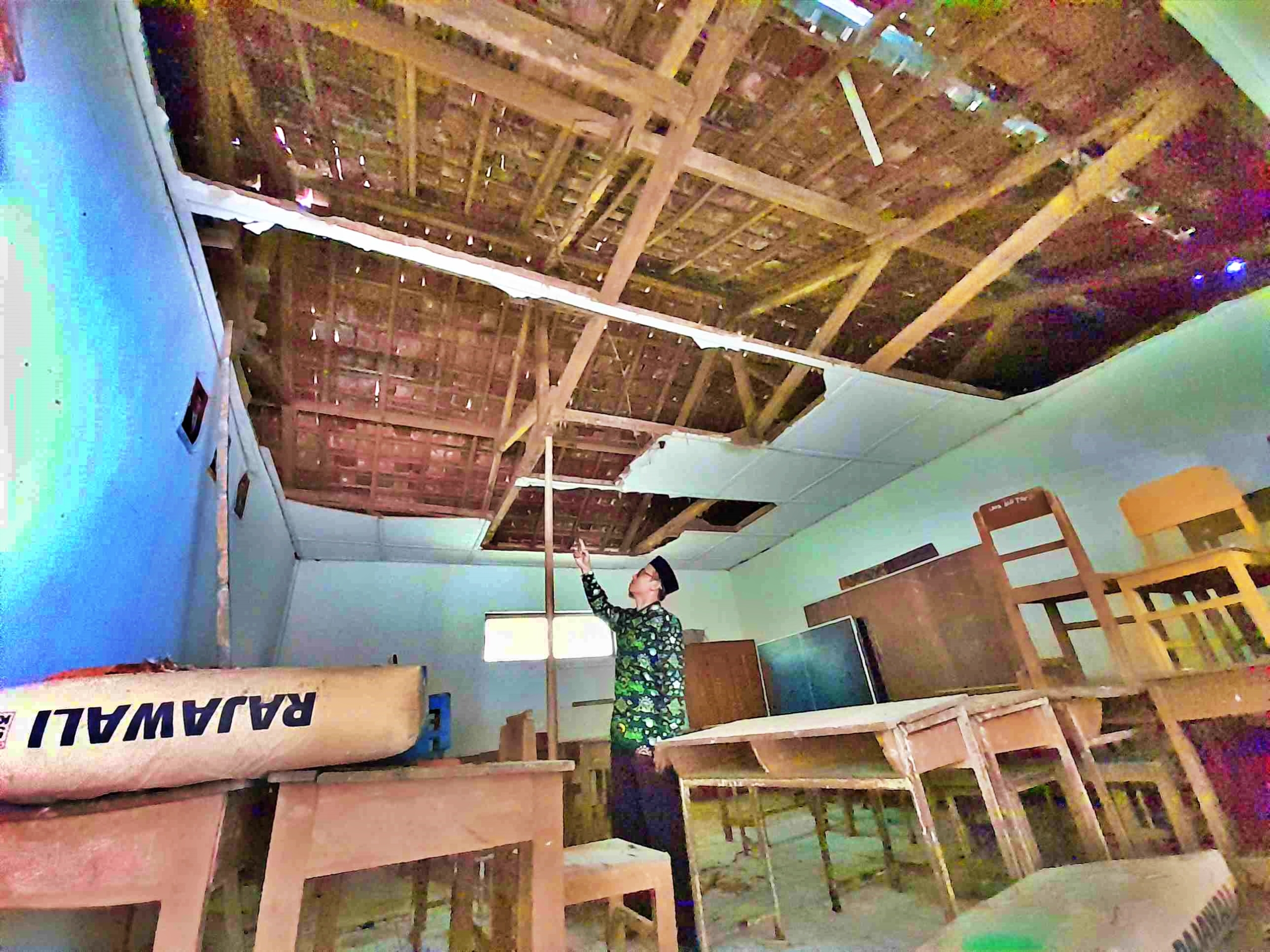 Seorang guru saat menunjukan kondisi bangunan Madrasah Ibtidaiyah (MI) Sirojul Munir di Windusari