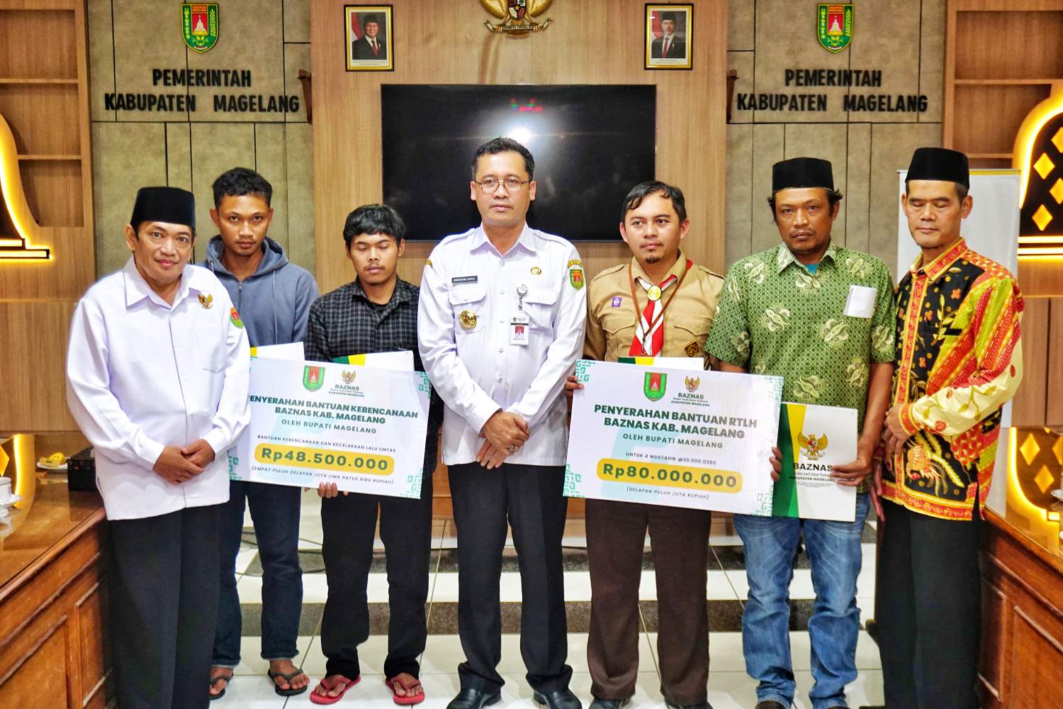 Bupati Magelang Grengseng Pamuji bersama Ketua BAZNAS Kabupaten Magelang M. Kholid As'adi saat menyerahkan pentasyarufan bantuan bencana alam dan RTLH