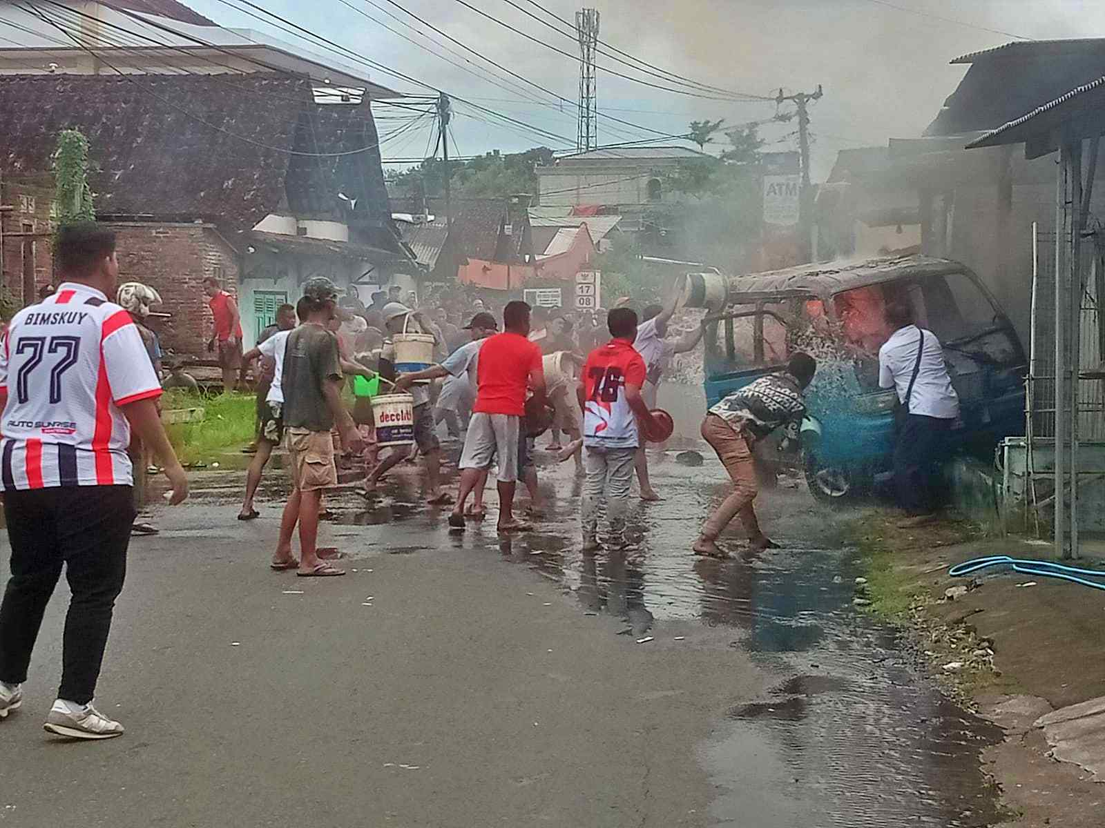 Warga mencoba memadamkan mobil angkot yang terbakar di Secang Magelang