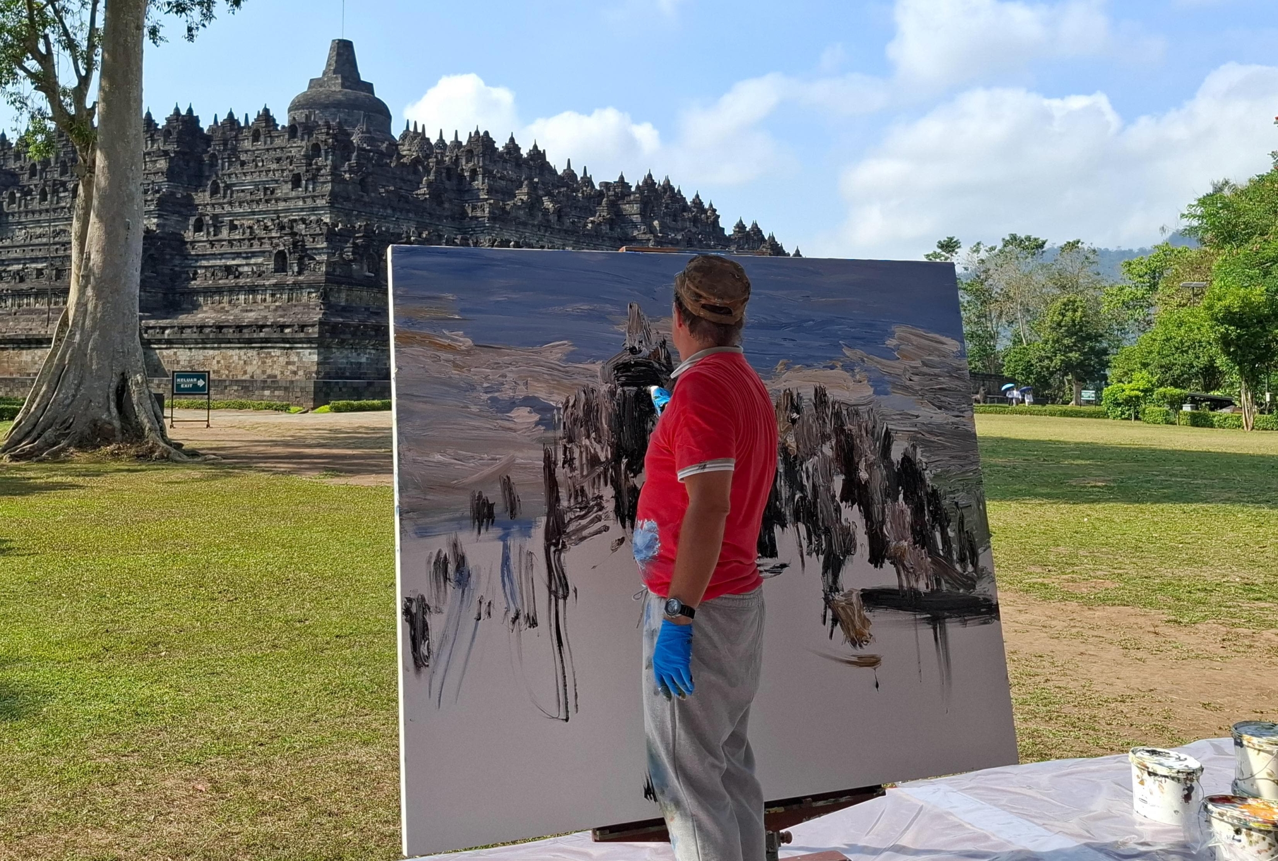 Pelukis asal Jerman, 
Christopher Lehmpfuhl melukis Candi Borobudur, di halaman Kenari, kompleks Candi Borobudur pada Senin (4/8/2025). (foto: mta)