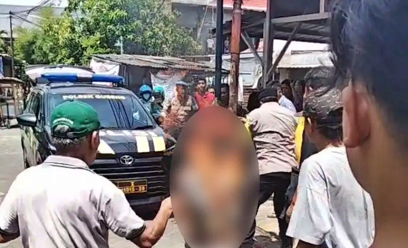 Petugas mencoba memadamkan api yang membakar tubuh terduga maling motor yang diikat di tiang listrik